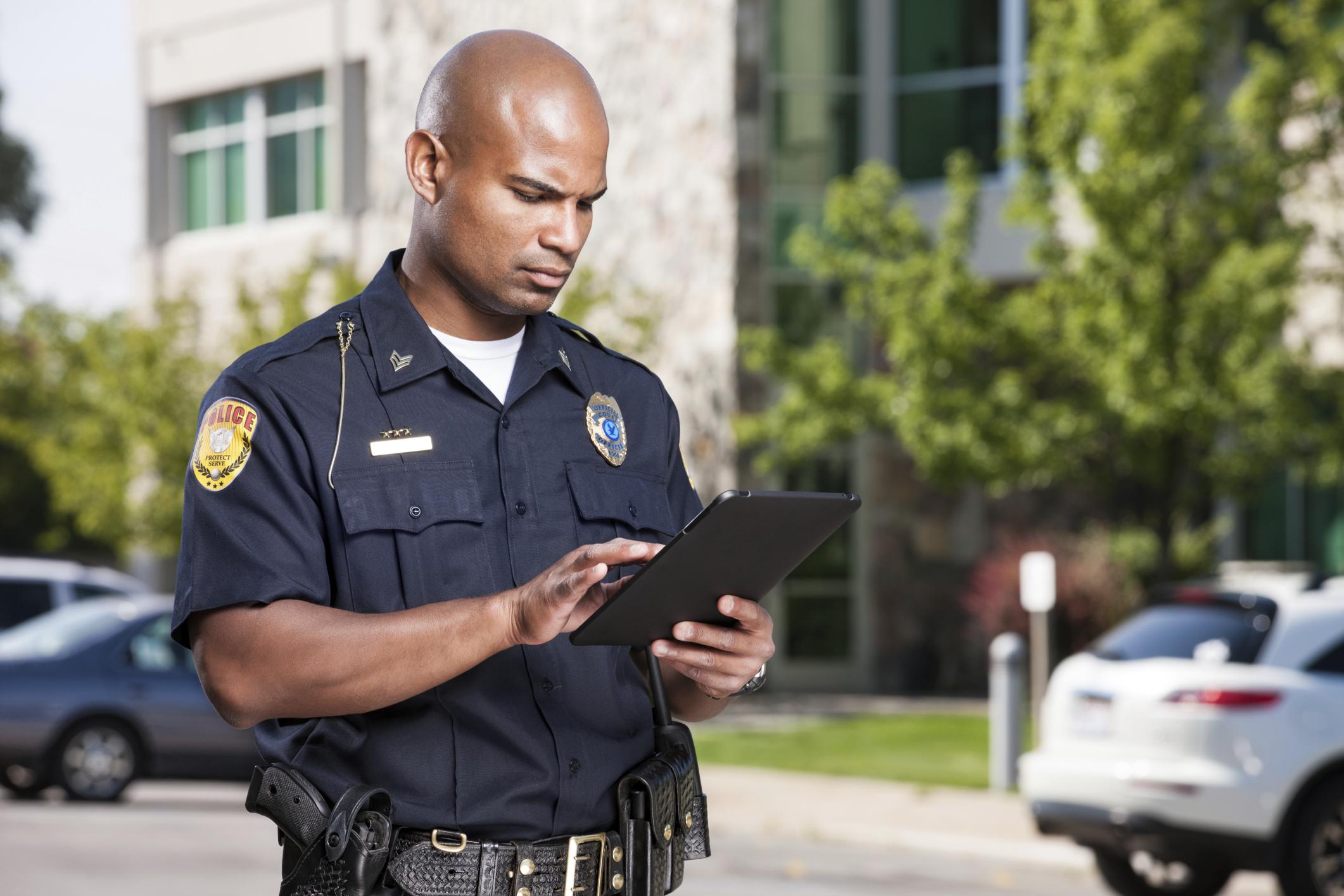 Oficial de policía con una tableta que se gestiona y protege mediante la solución SOTI ONE Platform